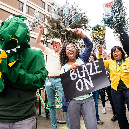 Group of people celebrating with shakers and signs.