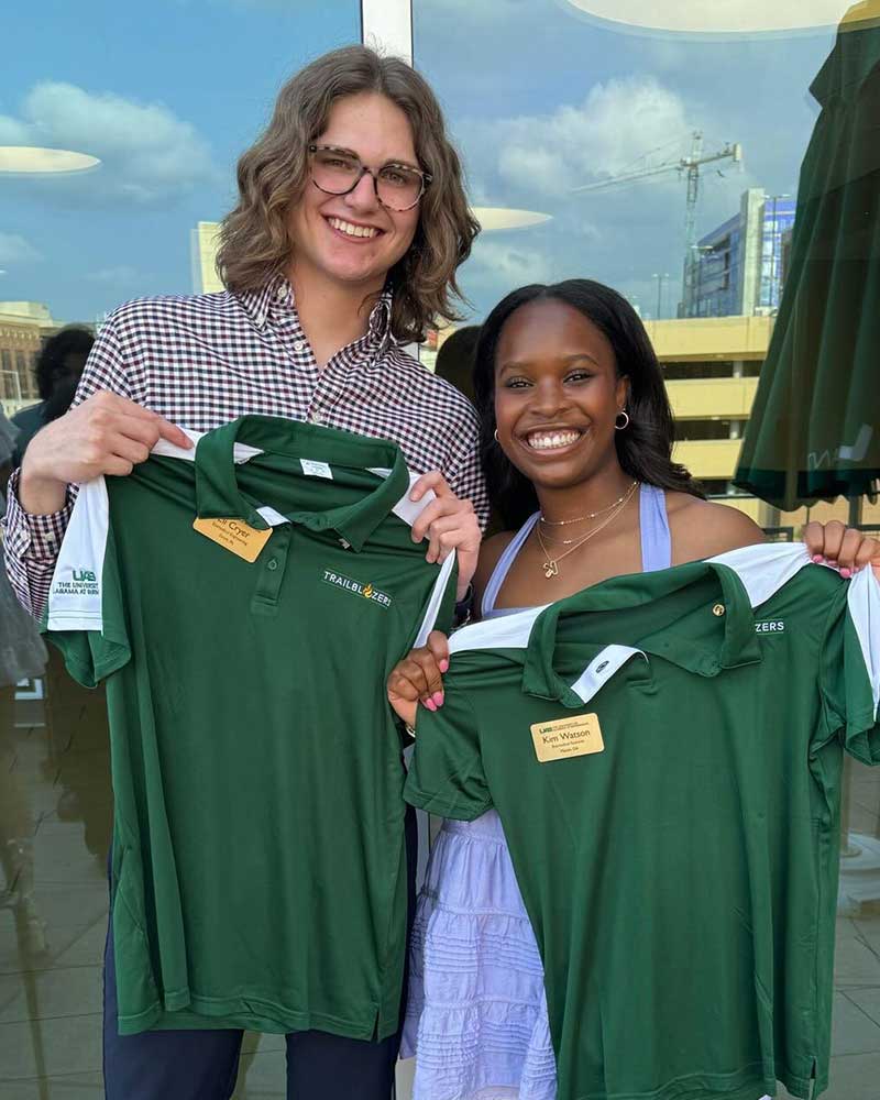 Two Trailblazers possing with the Trailblazer uniform shirt.