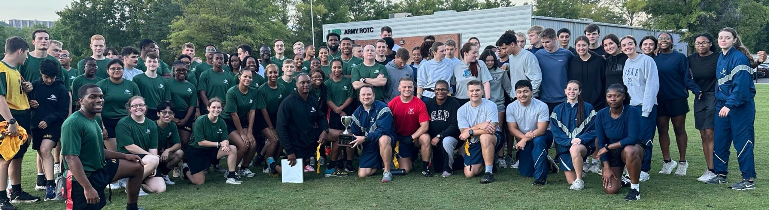 UAB Army ROTC students pose with air force cadets on a field.