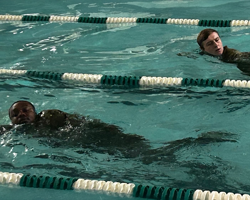 Students swimming laps in a pool.
