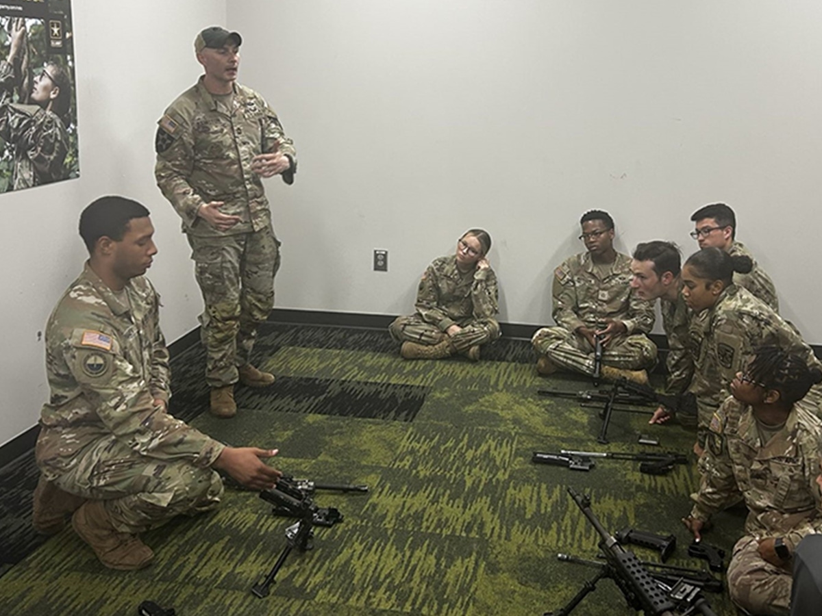 Trainees sitting on the floor listening to a speaker.