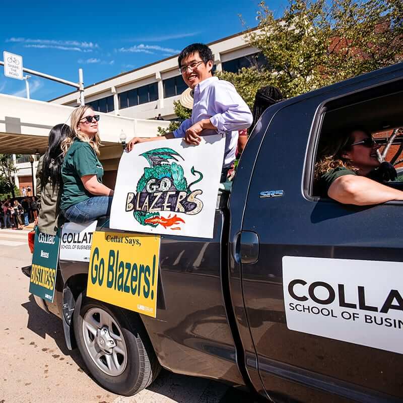 Collat students riding in the back of a truck in the UB homecoming parade.
