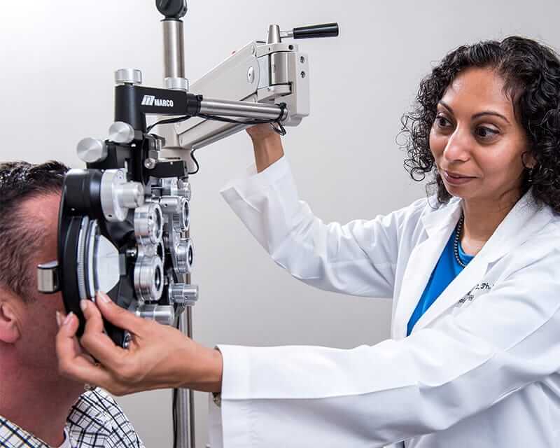 A femal optometrist performing an eye exam.