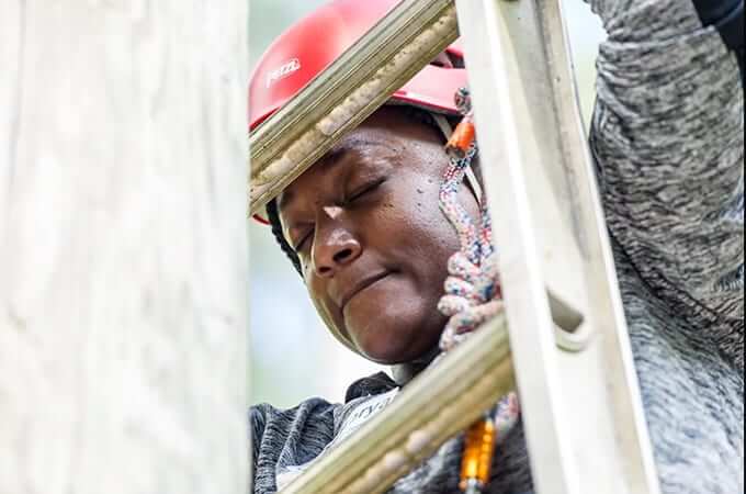 Black woman scaling a ladder.