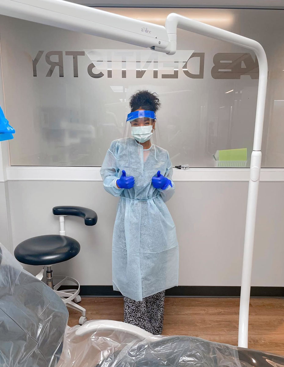 Jada standing in the UAB Dentistry building giving two thumbs up. 
