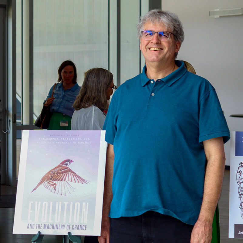  Professor Abrams stands next to a poster of his book cover. 