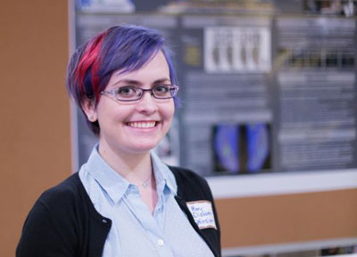 A female psychology student with purple hair presenting her research. 