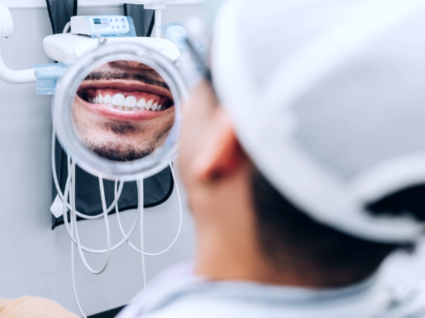 Man smiling in the mirror at a UAB Dentistry clinic