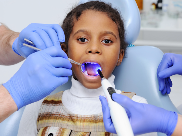 Stock image of child having dental sealants applied to her molars.