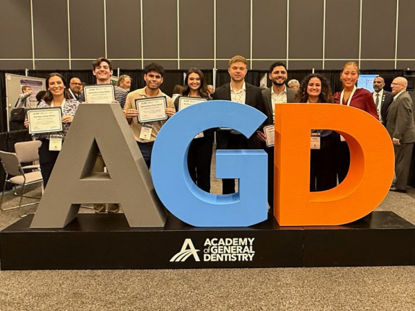 UAB dental students holding awards in front of AGD sign at AGD Scientific Session 2025