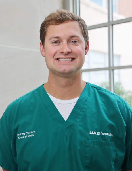 Smiling young man in green scrubs