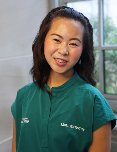 Smiling young woman in green scrubs