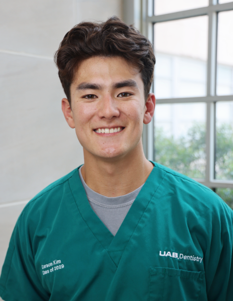 Smiling young man in green scrubs