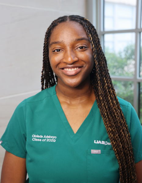 Smiling young woman in green scrubs