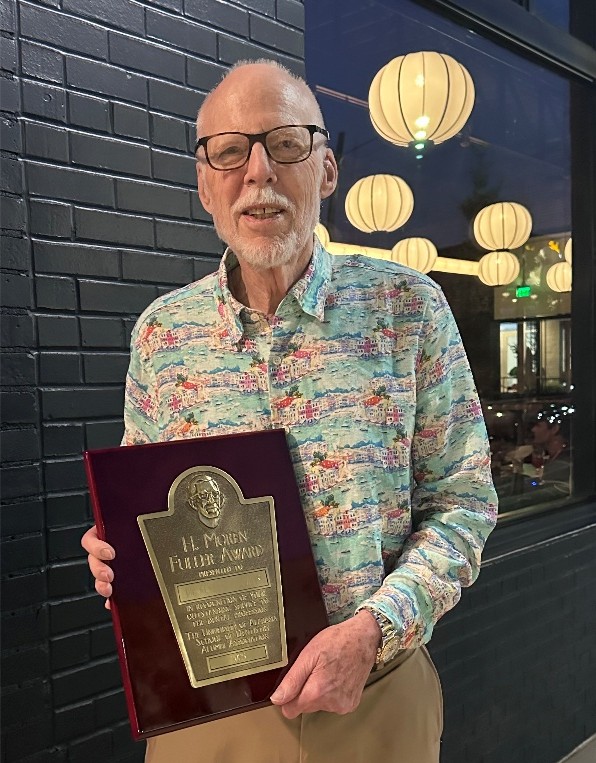 Dr. Palcanis holding award
