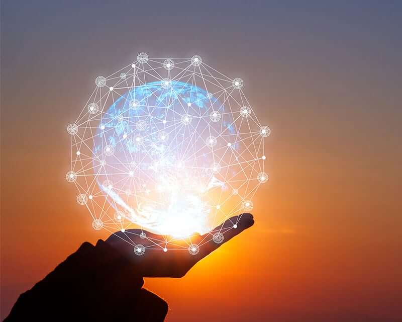 A hand holding a digitally connected globe.