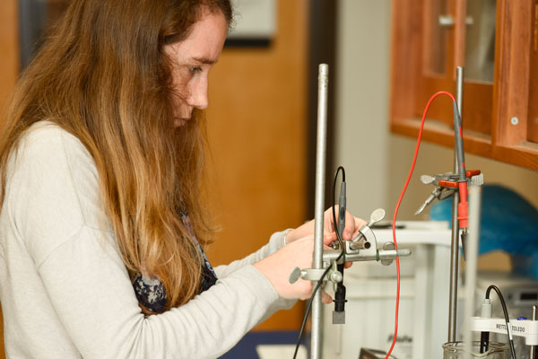 Student performing experiment in lab.