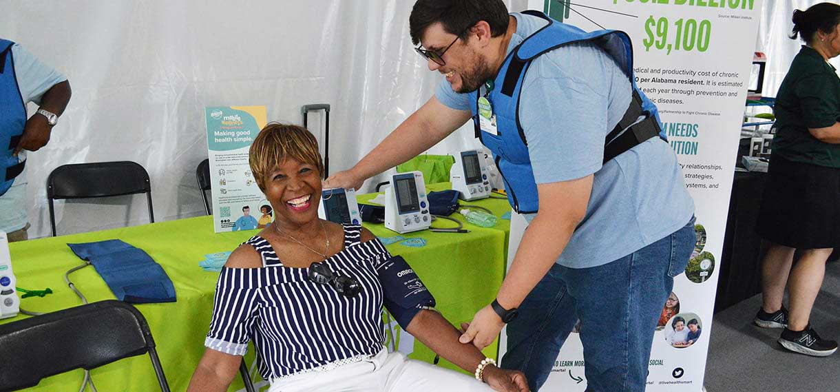 Smiling Black woman getting her blood pressure checked.
