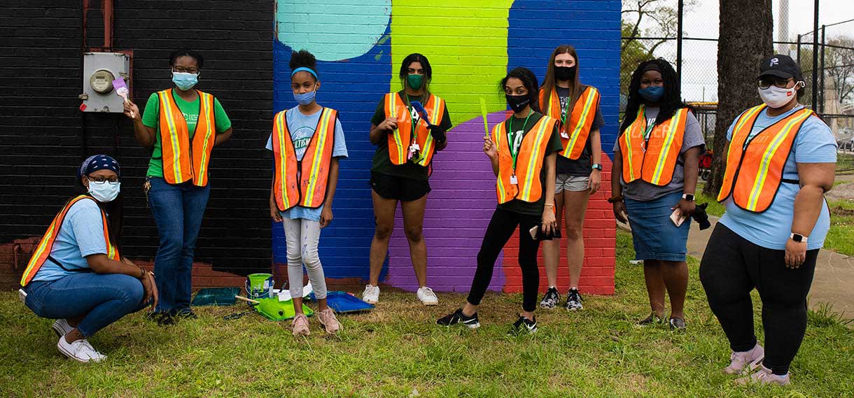 Volunteers in facemasks and orange safety vests.