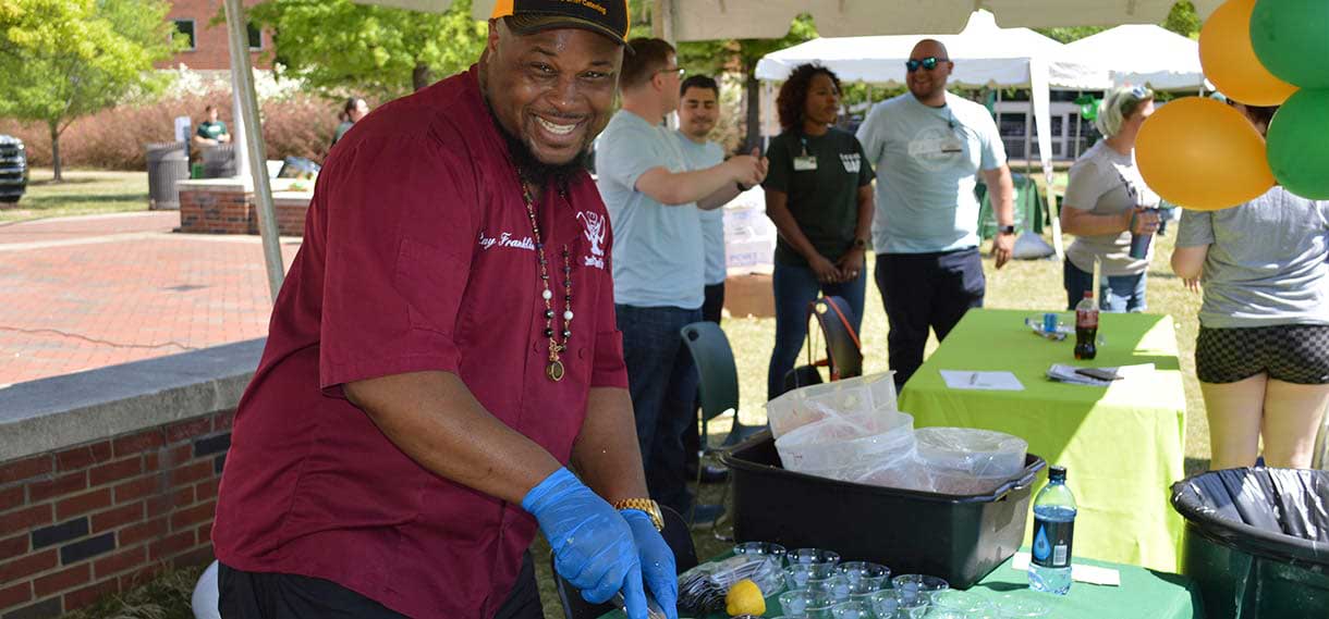 Smiling Black male volunteer at an outdoor event.