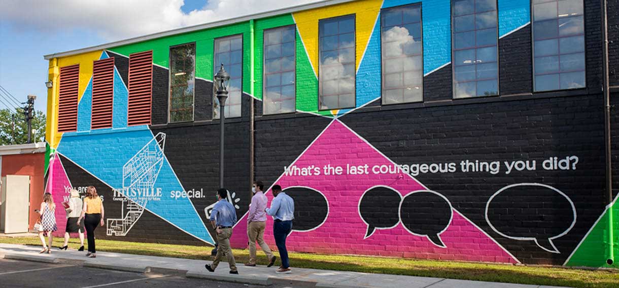 The new mural with pedestrians walking past.