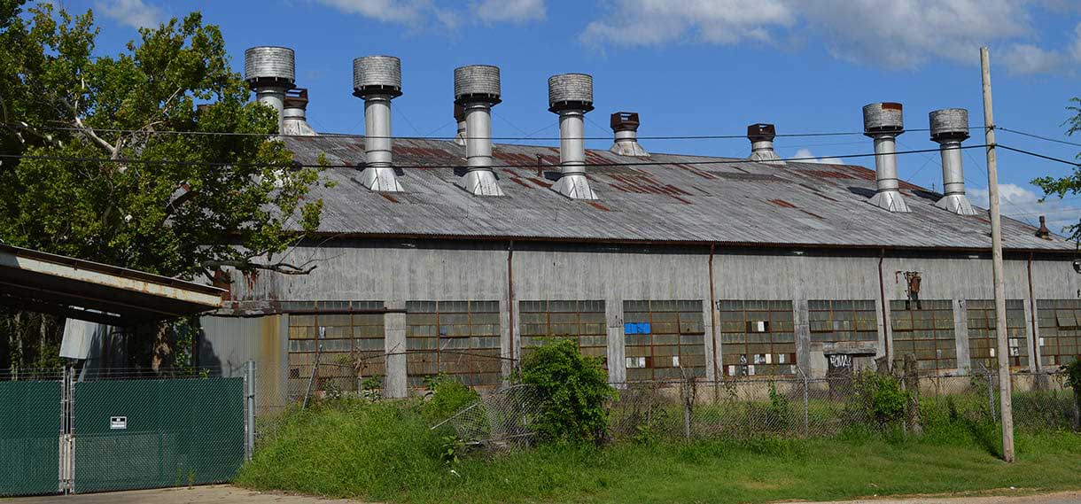 An old factory with many large ventilation or other towers coming from the roof.