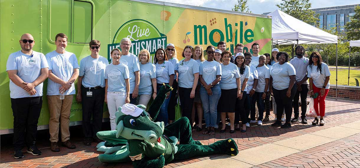 Blaze and Live HealthSmart volunteers outside the Mobile Market van.