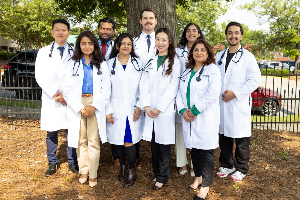 a gropu of young people in medical white coats paoses outside