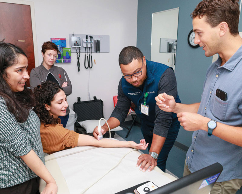 Students testing the POCUS system on an elbow joint.