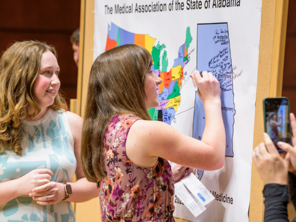 Heersink School of Medicine student signs map on Match Day