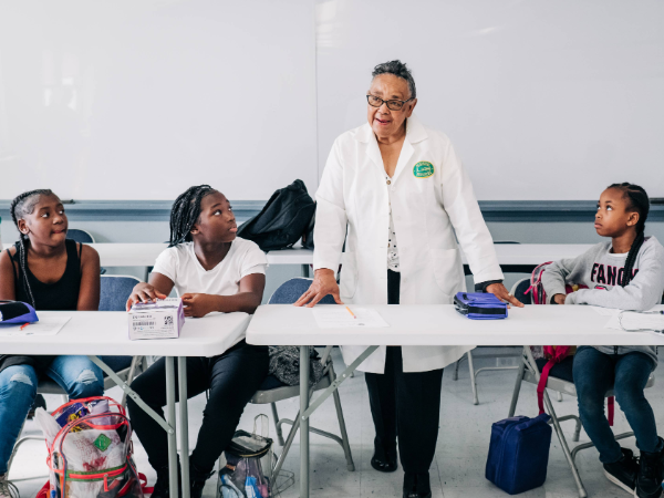Medical professional in a white coat with students