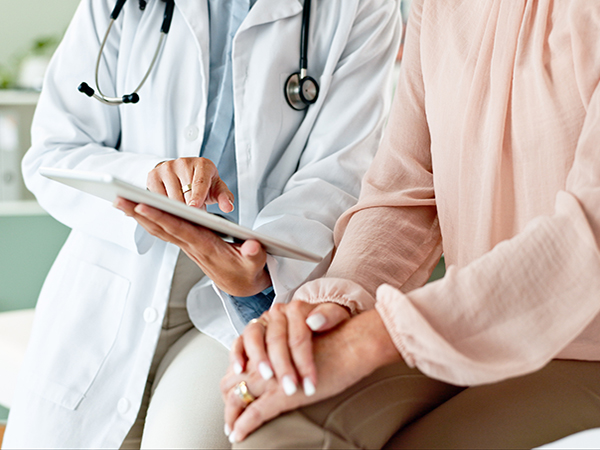 Physician sits with patient discussing medical treatment