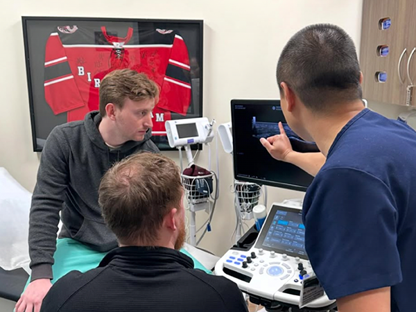 Physician trains medical residents on an ultrasound machine.