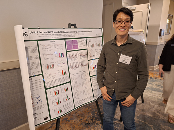 Man in front of research poster
