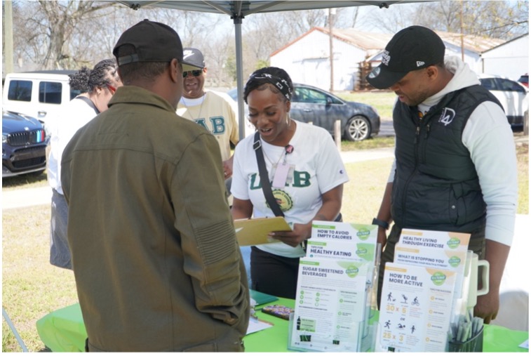 Community coach sharing flyers on good nutrition and physical activity with community members