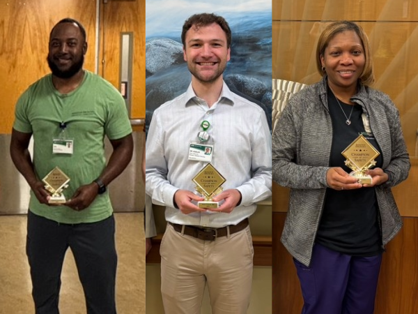 Three champion of safety winners, man in green shirt, man in white shirt, and woman in black shirt, all holding a plaque