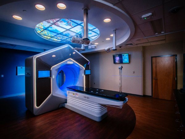 Dark room with machine lit up with blue lights that is ready for patient