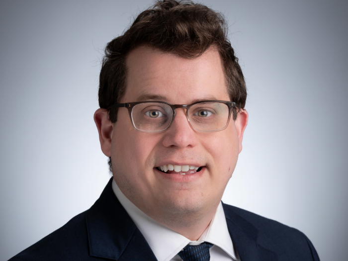 Headshot of Tylor Lewis, Ph.D., in front of a gray background.