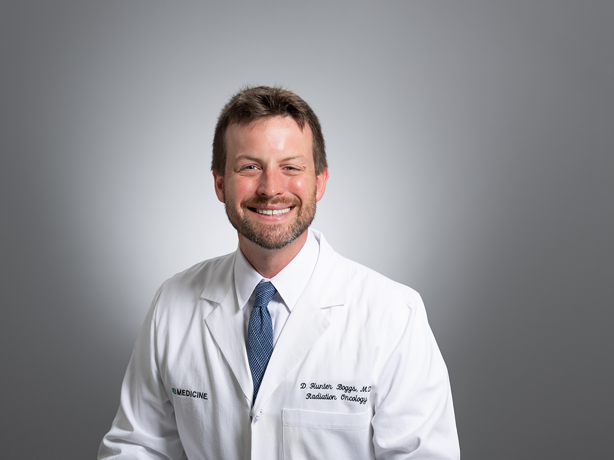  Headshot of Dr. D.. Hunter Boggs, MD (Associate Professor, Radiation Oncology) in white medical coat, July 2024.