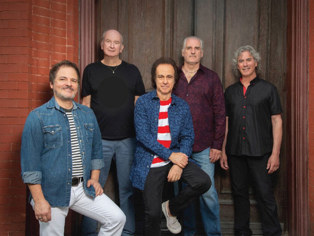 Five men posing for a photo in different styles