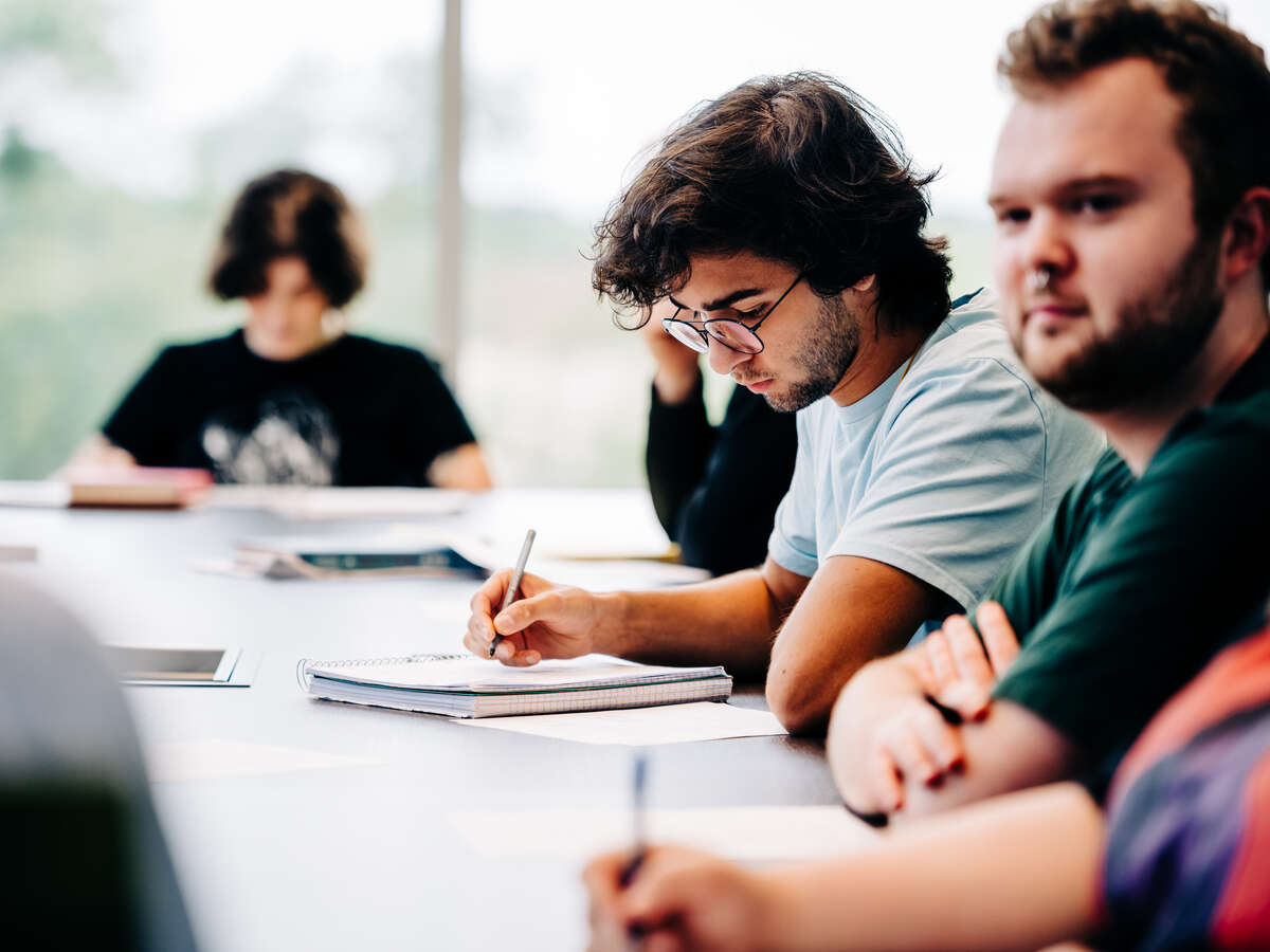 Students sitting at a long table in a conference room classroom in University Hall, September 2022.