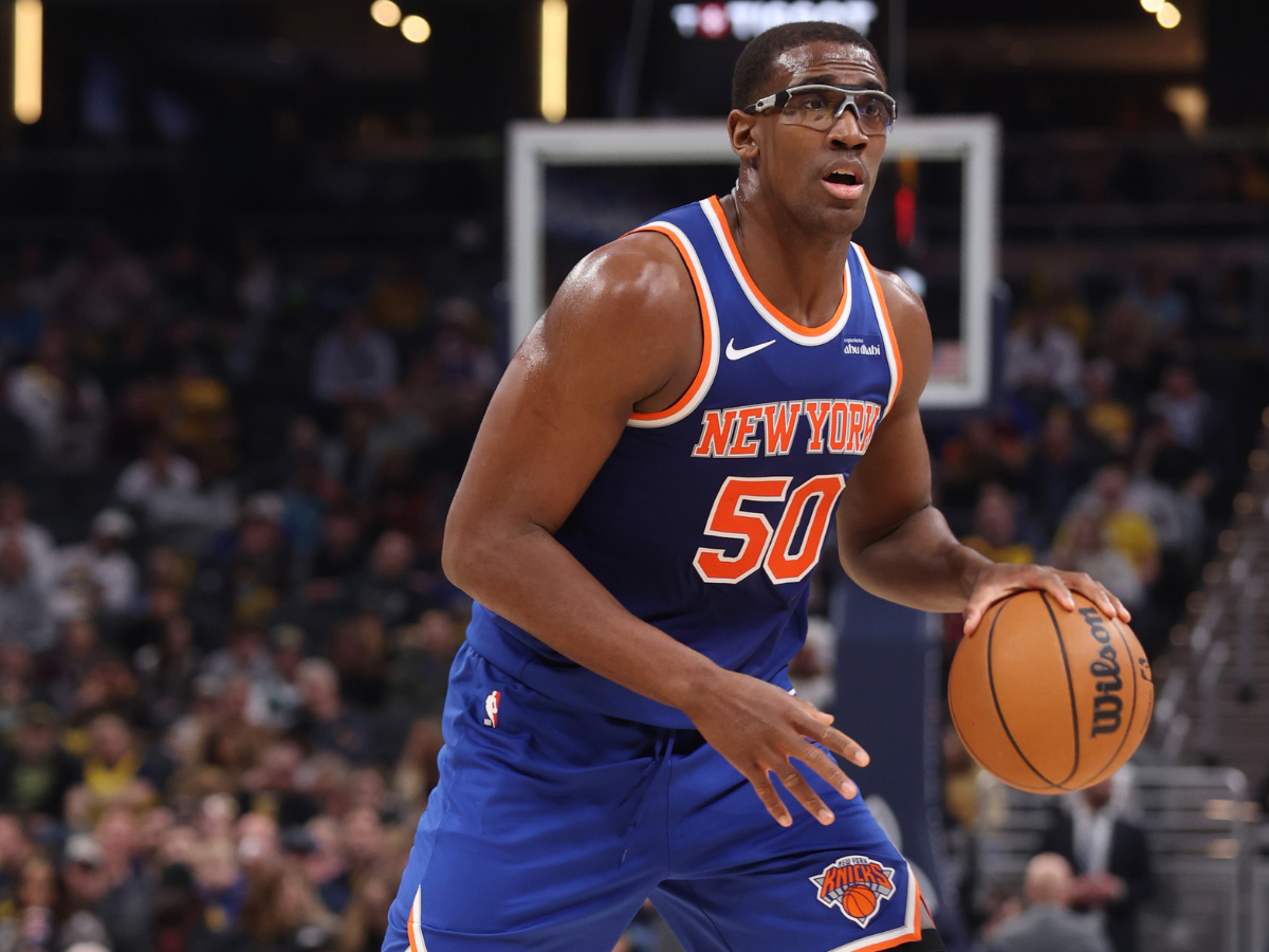 Trey Jemison the third, NBA basketball player for the New York Knicks, dribbling a basketball on a basketball court while wearing a blue jersey and protective eyewear