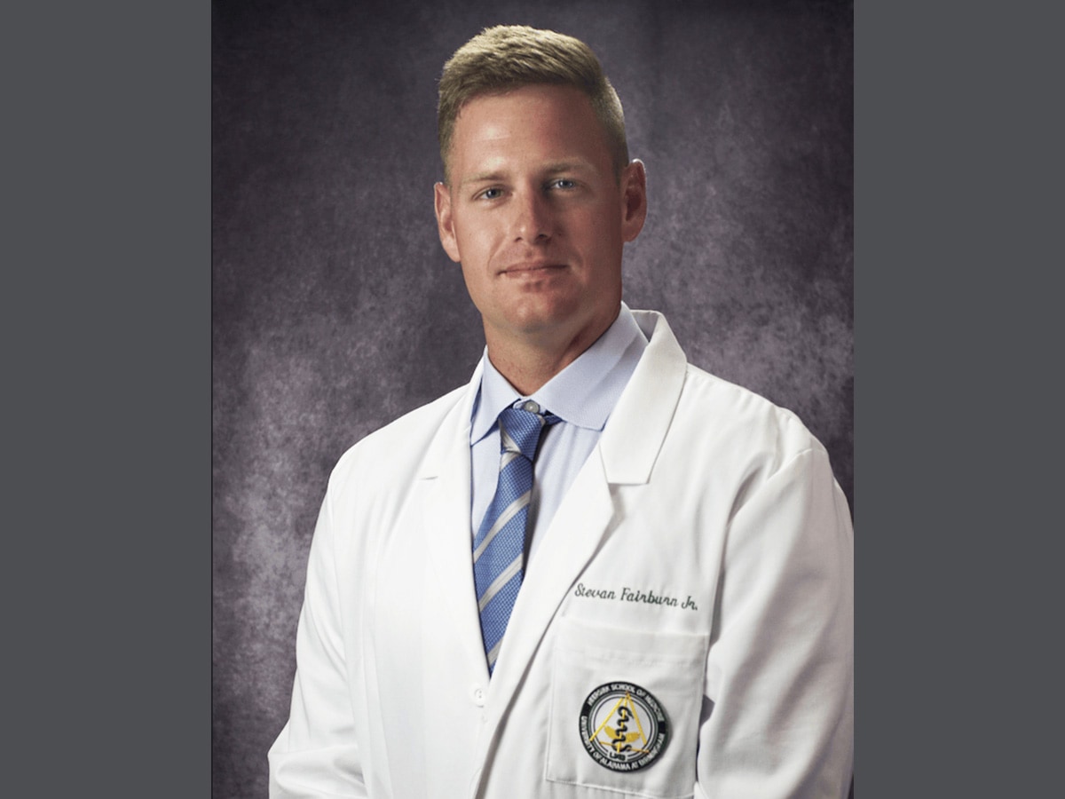 Indoor headshot of Stevan Fairburn wearing a medical white coat