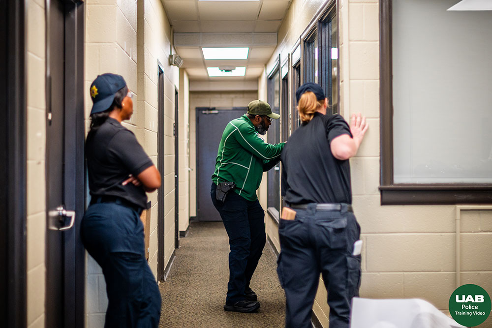 Three officers look toward an open doorway during a training exercise