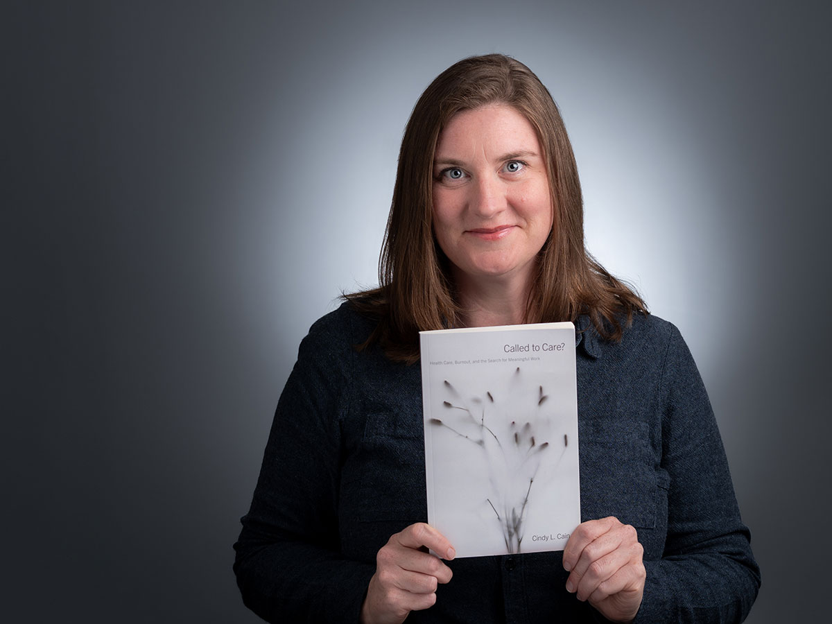 UAB sociologist Cindy Cain, Ph.D., holds a copy of her new book, "Called to Care"