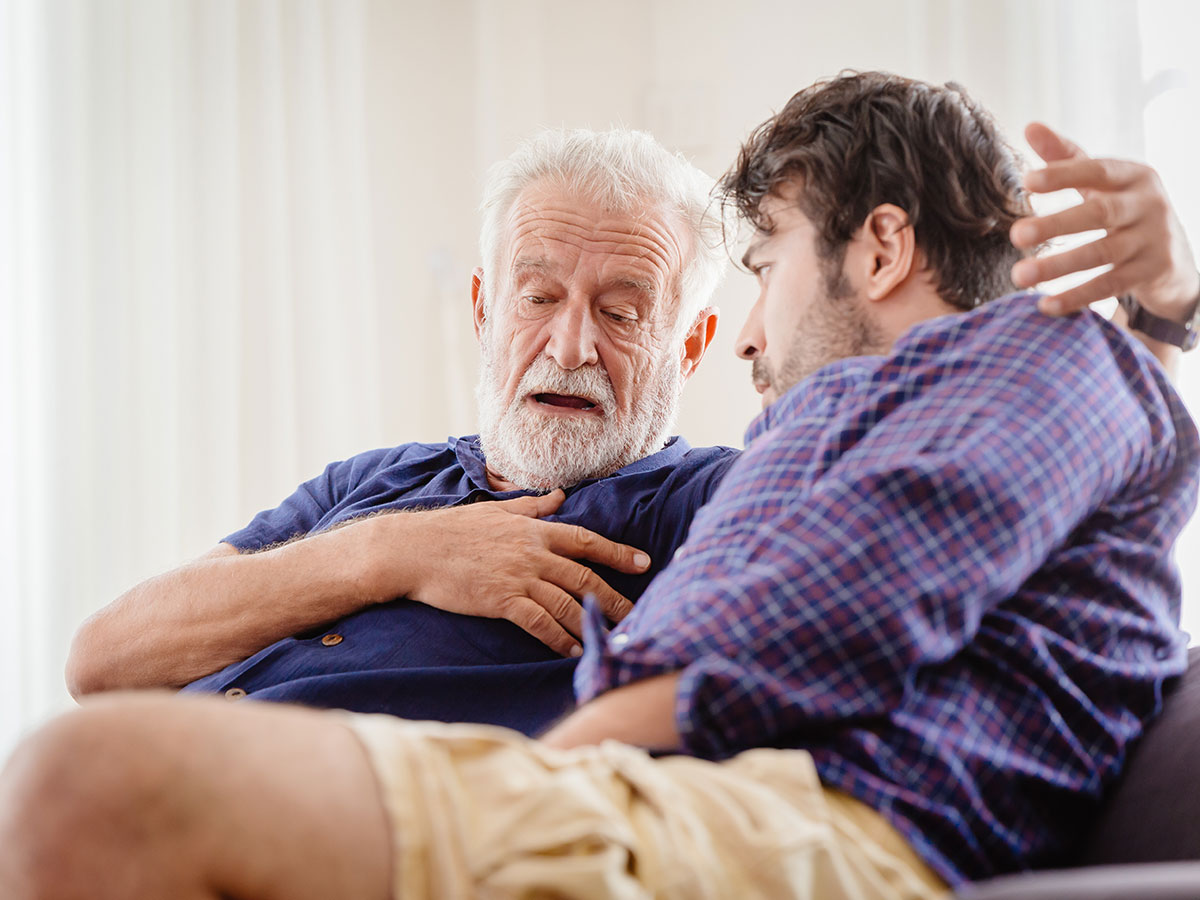 An older man talks animatedly to a younger man