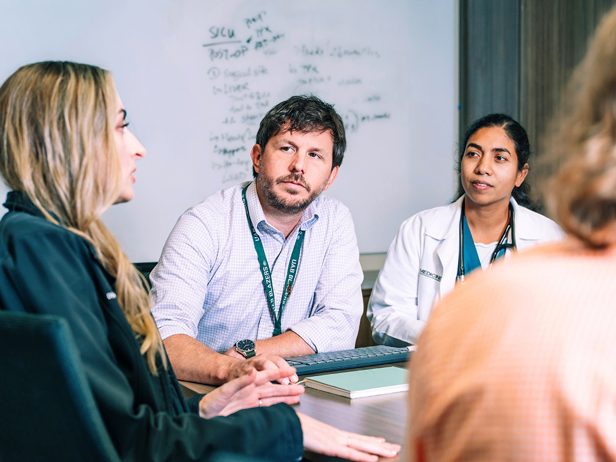 Four members of the Immunocompromised Infectious Diseases team discuss a patient case around a conference table