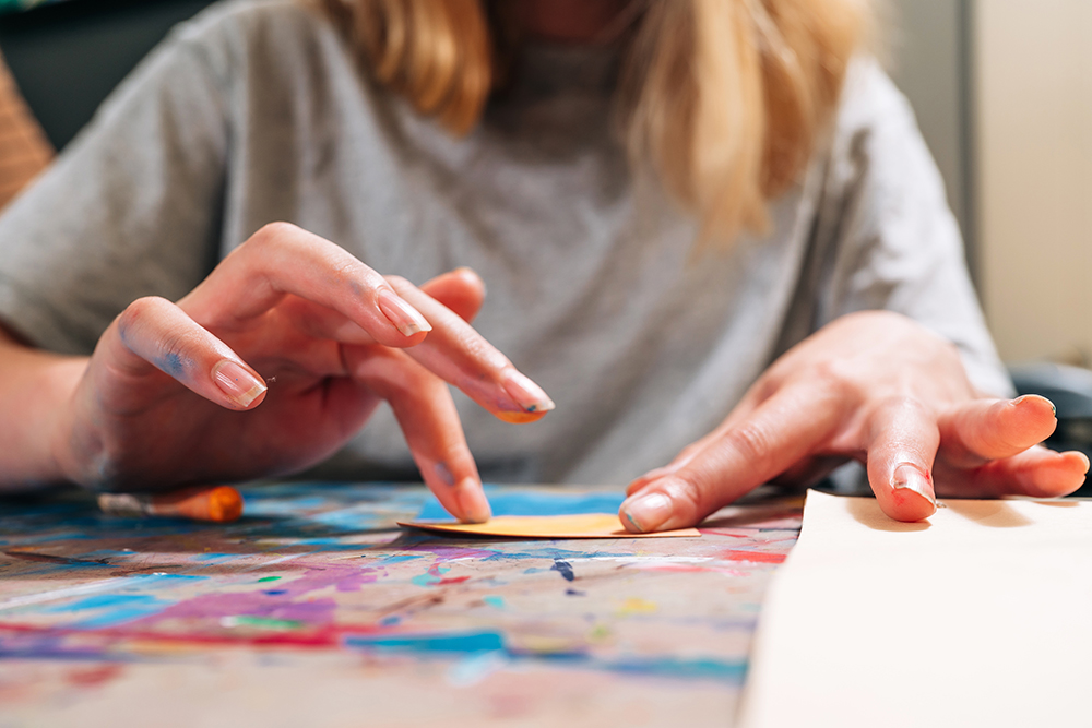 Hands applying paint to canvas at ArtPlay summer camp