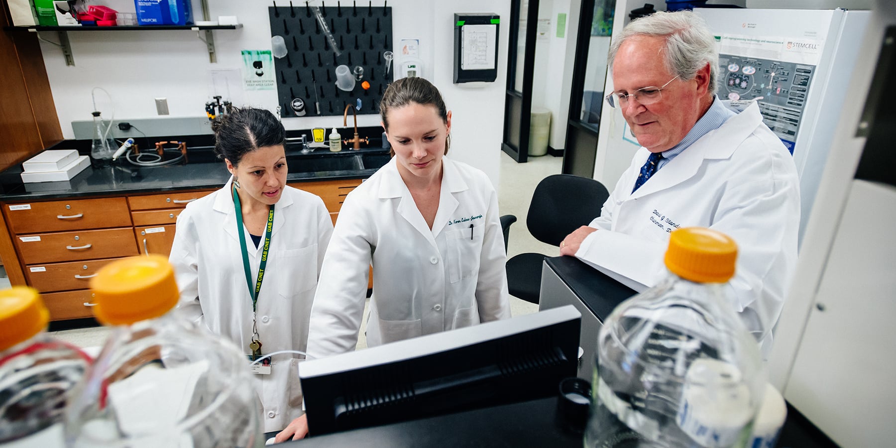 Faculty member supervising students in a lab.