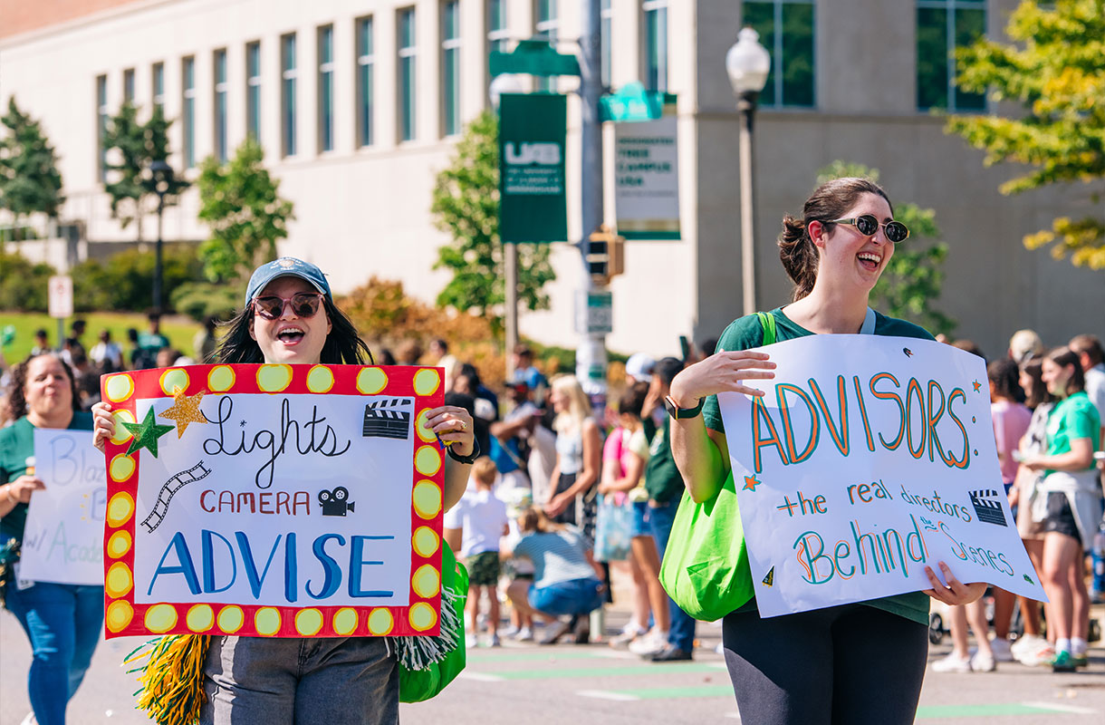 UAB Advisors in the UAB Homecoming parade, holding signs